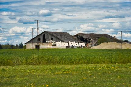 Abandoned Farmhouse in Green Countryside Under Cloudy Sky